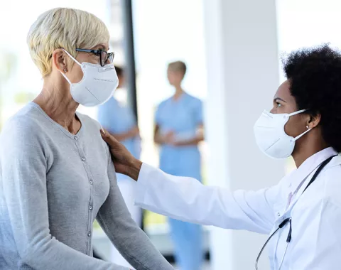 Doctor speaking with patient; both in masks